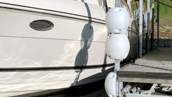 Two White WhamGuard Rotating Bumpers mounted on dock post.
