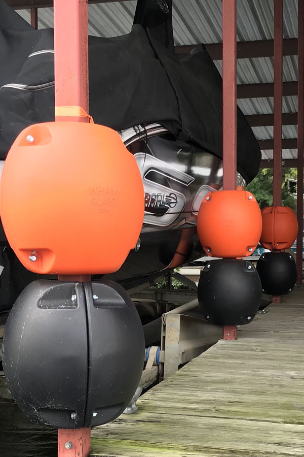 Two Blue Rotating Boat Dock Bumpers attached on a boat dock post