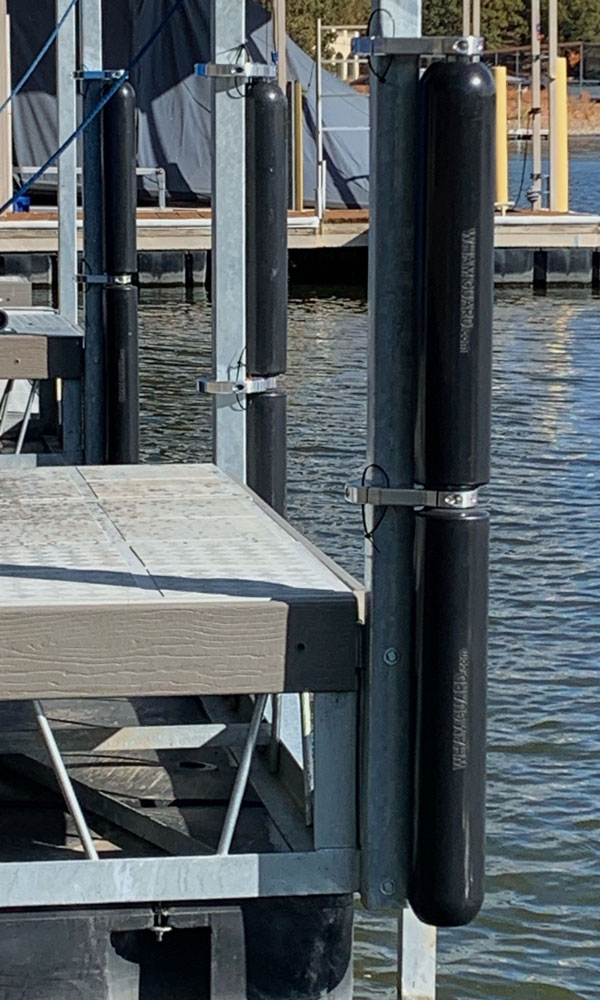 Two Blue Rotating Boat Dock Bumpers attached on a boat dock post